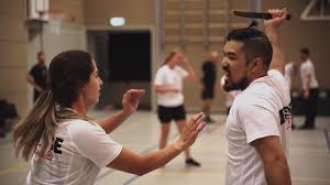 Deelnemers oefenen Krav Maga mesverdediging tijdens een intensieve zelfverdedigingstraining